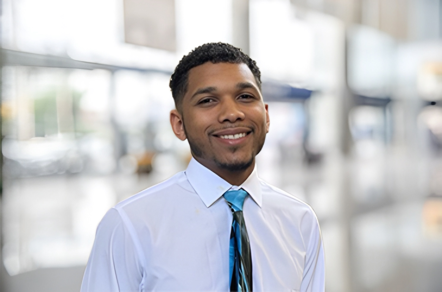 Caylan Wilcox, IT Specialist, smiling in office setting